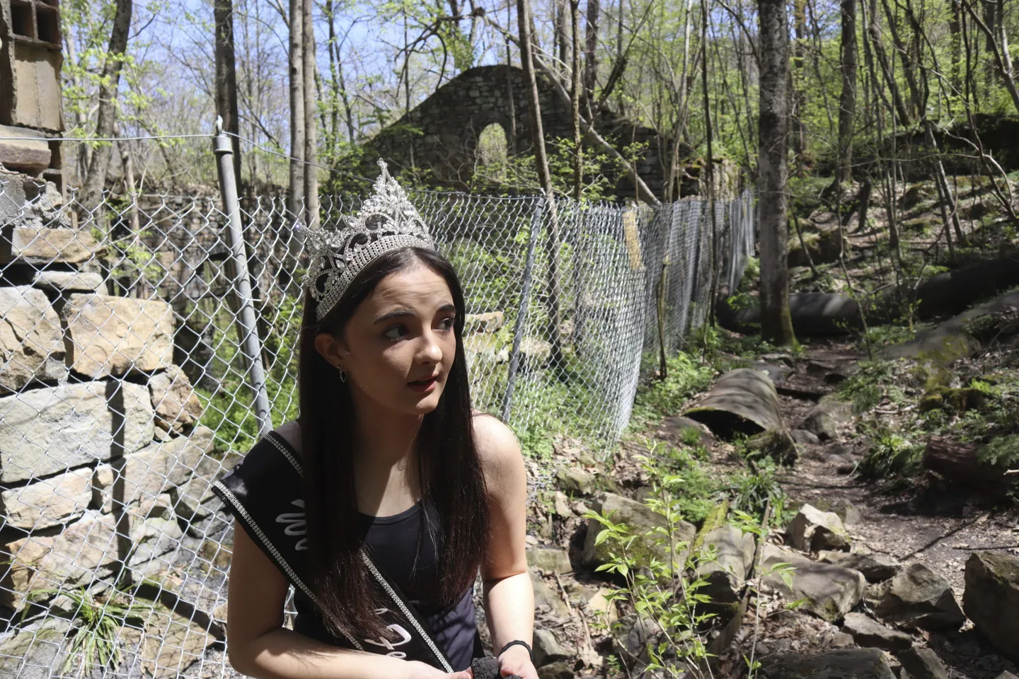 West Virginia Coal Festival teen beauty pageant winner Ava Johnson, 16, collects small pieces of coal left behind at the former Kay Moor coal town and camp in the New River Gorge National Park and Preserve near Fayetteville, W.Va., Thursday, April 17, 2025