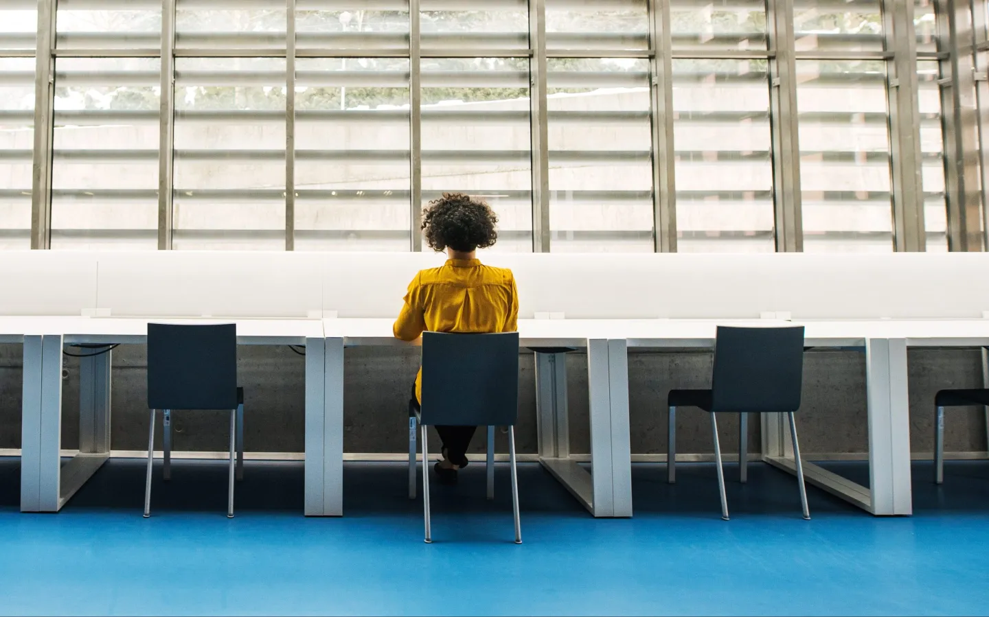 woman sitting next to empty desks