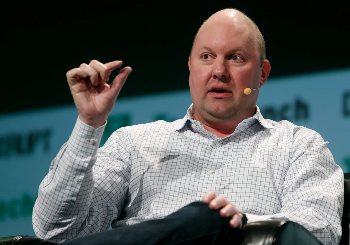 Marc Andreessen speaking on stage holding a hand up.