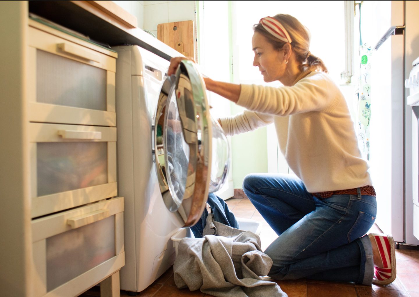 Woman loads a laundry machine
