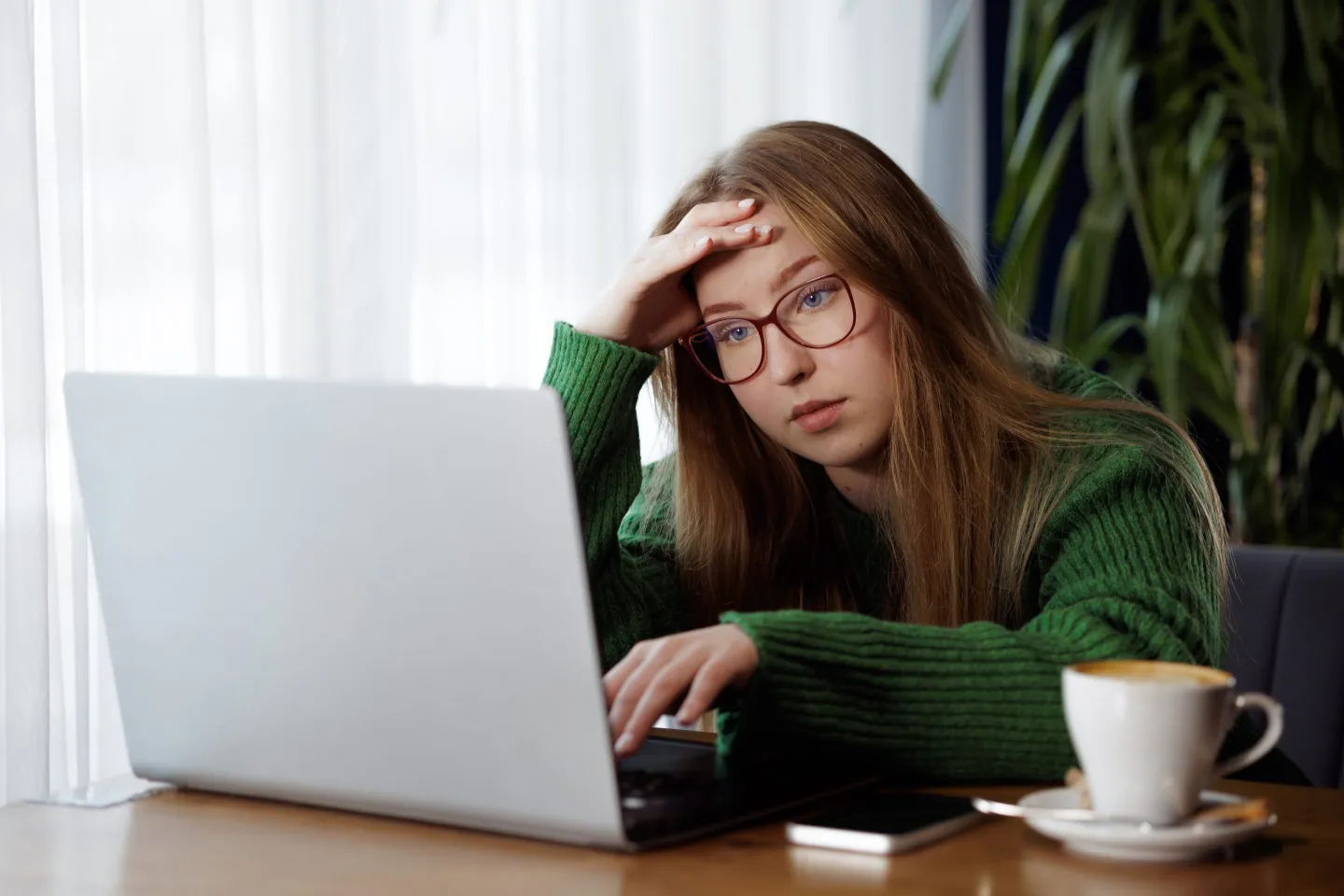 Distressed young girl at laptop