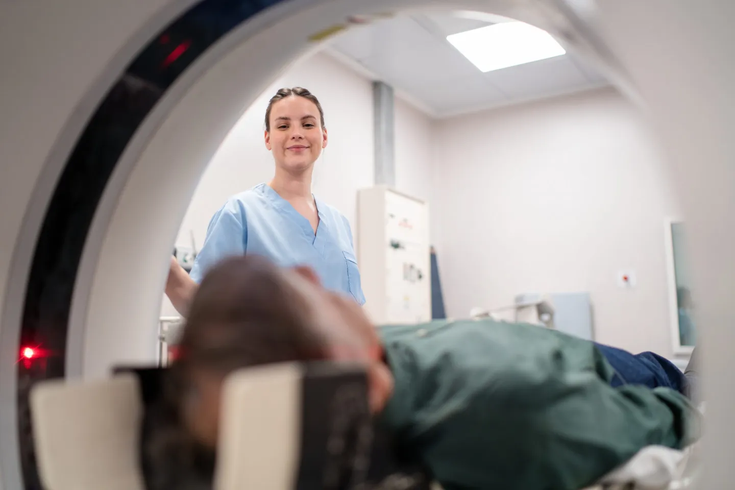 Technician leaning over a person getting an MRI