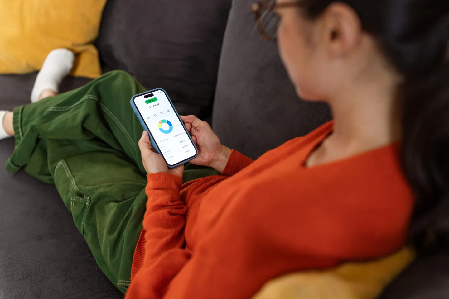 A person laying on a couch looking at their phone.
