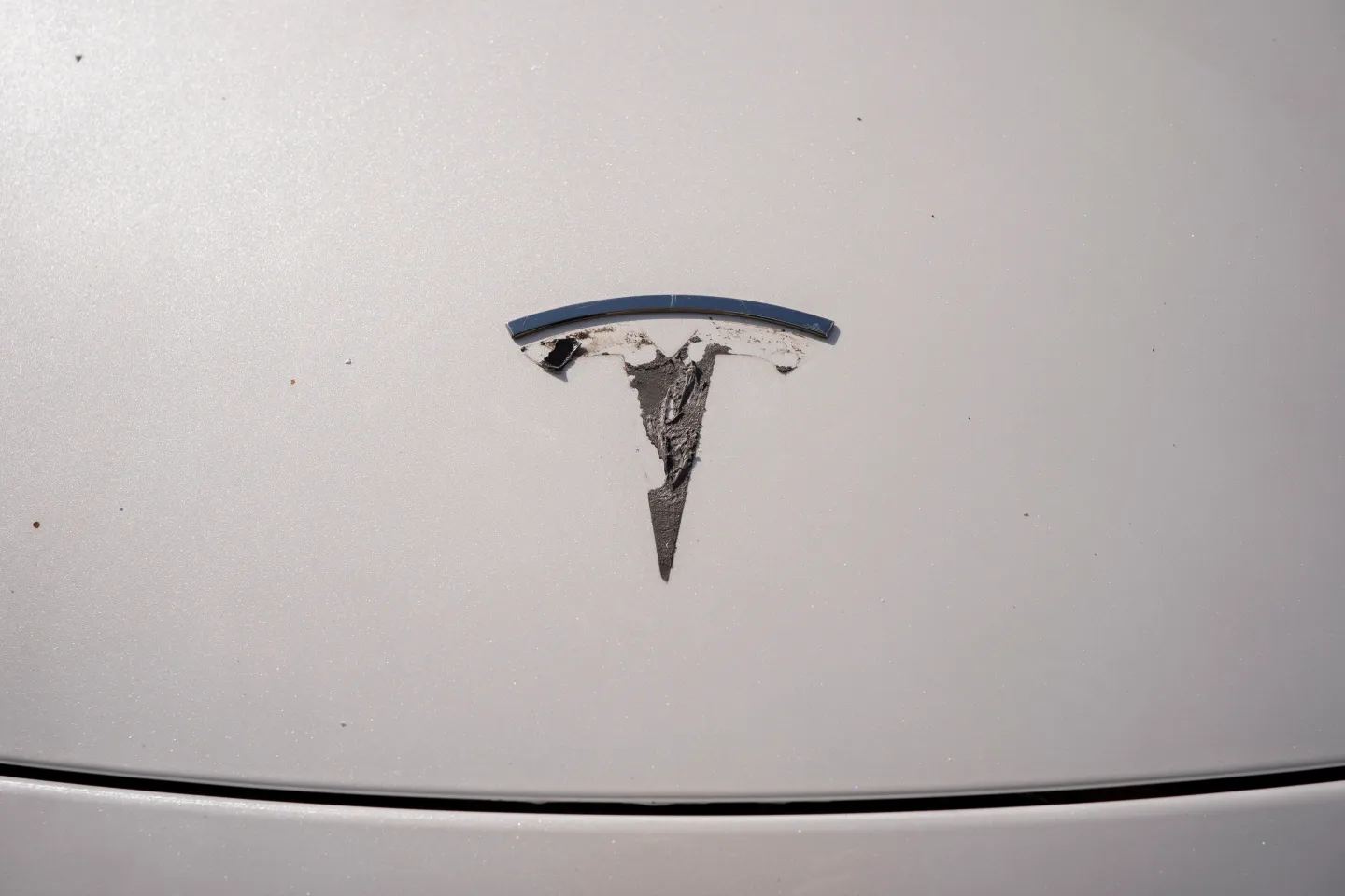 A Tesla emblem is being removed from a vehicle during a "de-badging" event on April 12, 2025 in Seattle, Washington. (Photo: David Ryder/Getty Images)