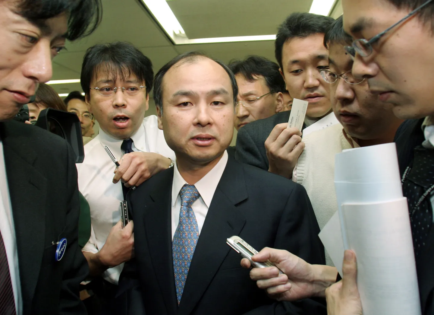 Masayoshi Son surrounded by reporters in 2004.